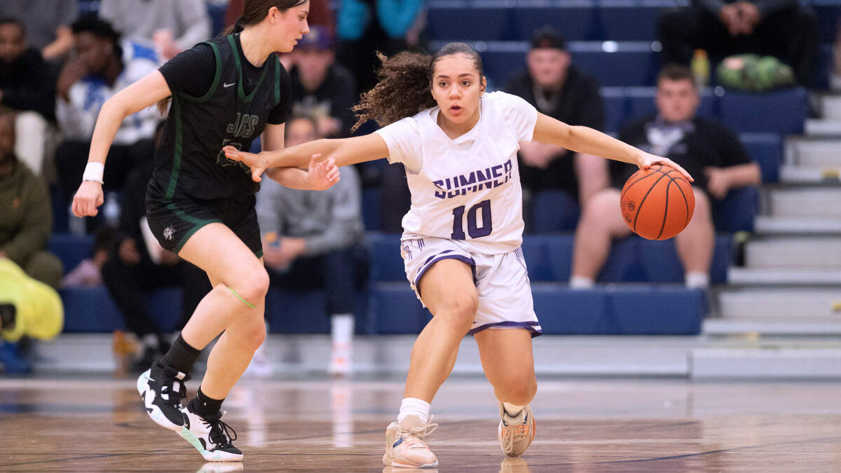 Sumner’s Olivis Collins (10) holds off Emerald Ridge defenderAlina Sapilak as she brings the ball up court during Saturday night’s 4A SPSL girls basketball tournament championship game at Tacoma Community College in Tacoma, Washington, on Feb. 4, 2023. Sumner held off a late Emerald Ridge rally to win the game, 50-48.