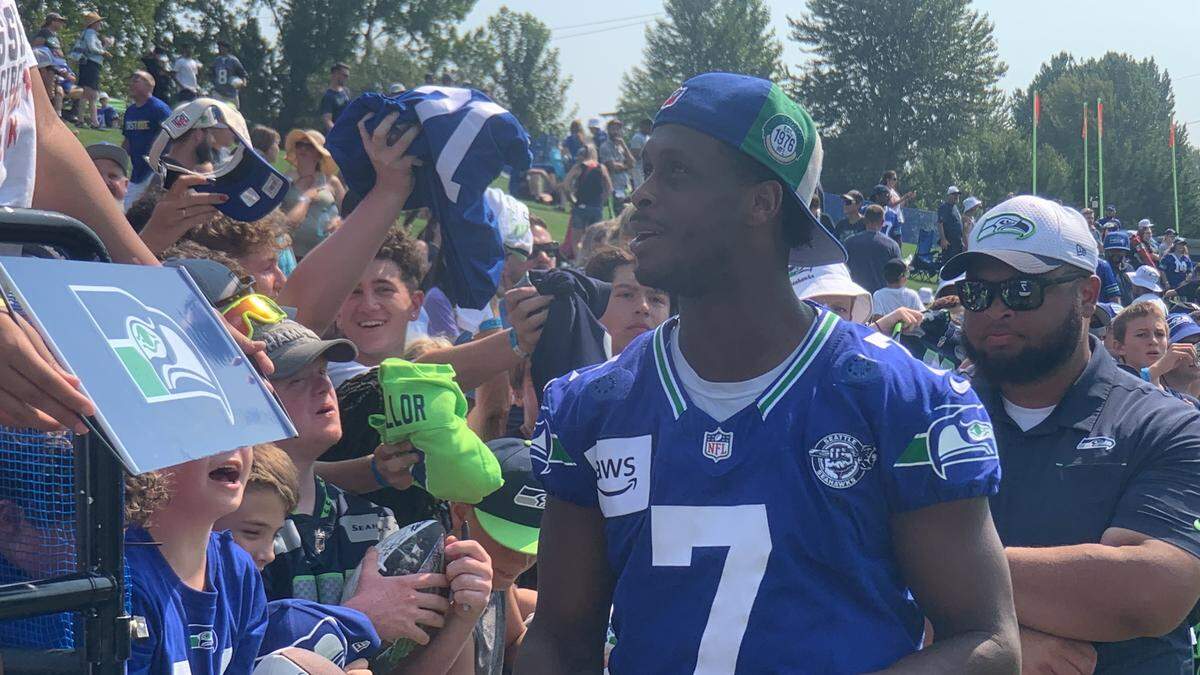 Pro Bowl quarterback Geno Smith signs autographs for fans following the 14th practice of Seattle Seahawks training camp at the Virginia Mason Athletic Center in Renton, Aug. 8, 2024.