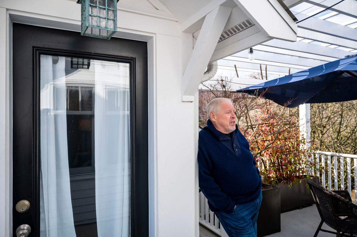 Paul Kadzik leans up against the side of his one-bedroom, short-term rental on the upper deck of his Gig Harbor, Wash. home on Thursday, Feb. 24, 2022.