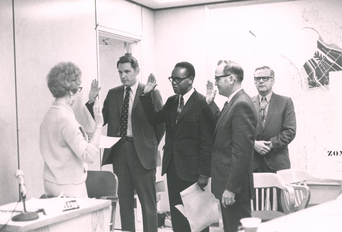 Harold Moss (center) raised his hand as he, along with Gerald Maule and Philip Schroeder, took the oath of office on October 13, 1970. Mr. Moss was appointed to the Tacoma City Council in the wake of political upheaval when five councilmen were ousted by recall. He was the first black to serve on the city council and would run successfully in 1971 to serve until 1973.