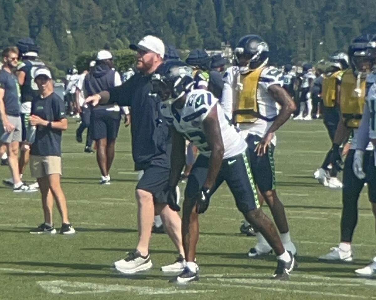 Special-teams coach Jay Harbaugh (white cap) next to safety D’Anthony Bell (23) during kickoff-coverage drills in Seattle Seahawks NFL training camp July 31, 2025, at the Virginia Mason Athletic Center in Renton.