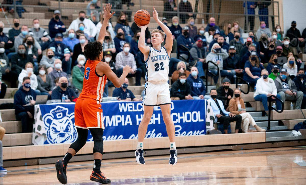 Olympia’s Parker Gerrits puts up a three-point shot over Graham-Kapowsin defender Joshua Wood during Friday night’s 4A SPSL league tournament boys basketball semifinal game at Olympia High School on Feb. 4, 2022.