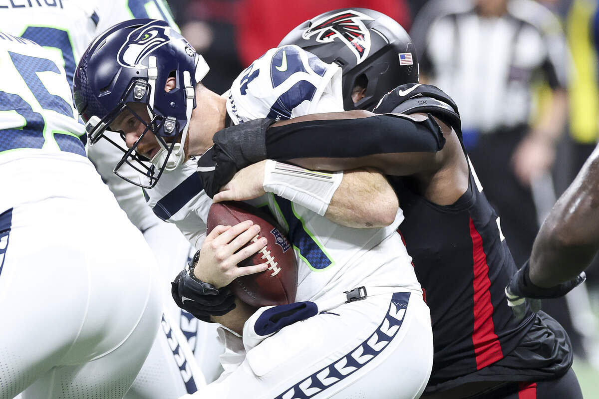 Sam Darnold (14) of the Seattle Seahawks is sacked by Kentavius Street (93) of the Atlanta Falcons during the second quarter at Mercedes-Benz Stadium on Dec. 7, 2025 in Atlanta.