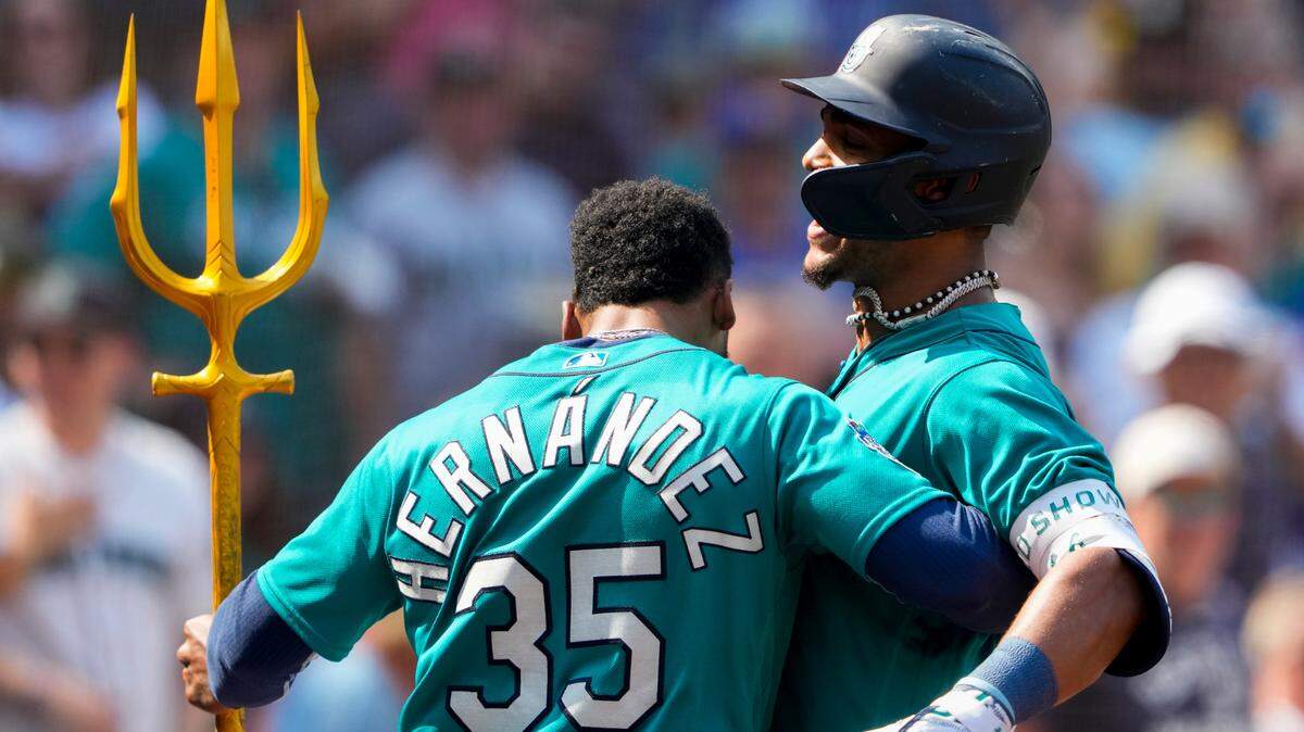 Seattle Mariners’ Julio Rodriguez, right, is hugged by teammate right fielder Teoscar Hernandez (35) after Rodriguez hit his 50th career home run, a two-run home run to score J.P. Crawford against the Kansas City Royals during the fifth inning of a baseball game Saturday, Aug. 26, 2023, in Seattle. Rodriguez is the fastest Mariners player to reach 50 career home runs in franchise history. (AP Photo/Lindsey Wasson)