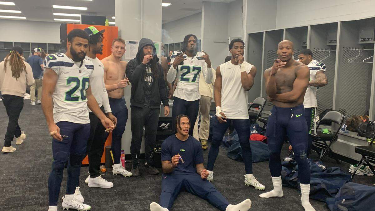 Seahawks players posing with cigars in the locker room at State Farm Stadium in Glendale, Arizona, after the team’s season-ending win over the Cardinals. Seattle (9-8) did not advance to the playoffs for only the third time in 12 years.