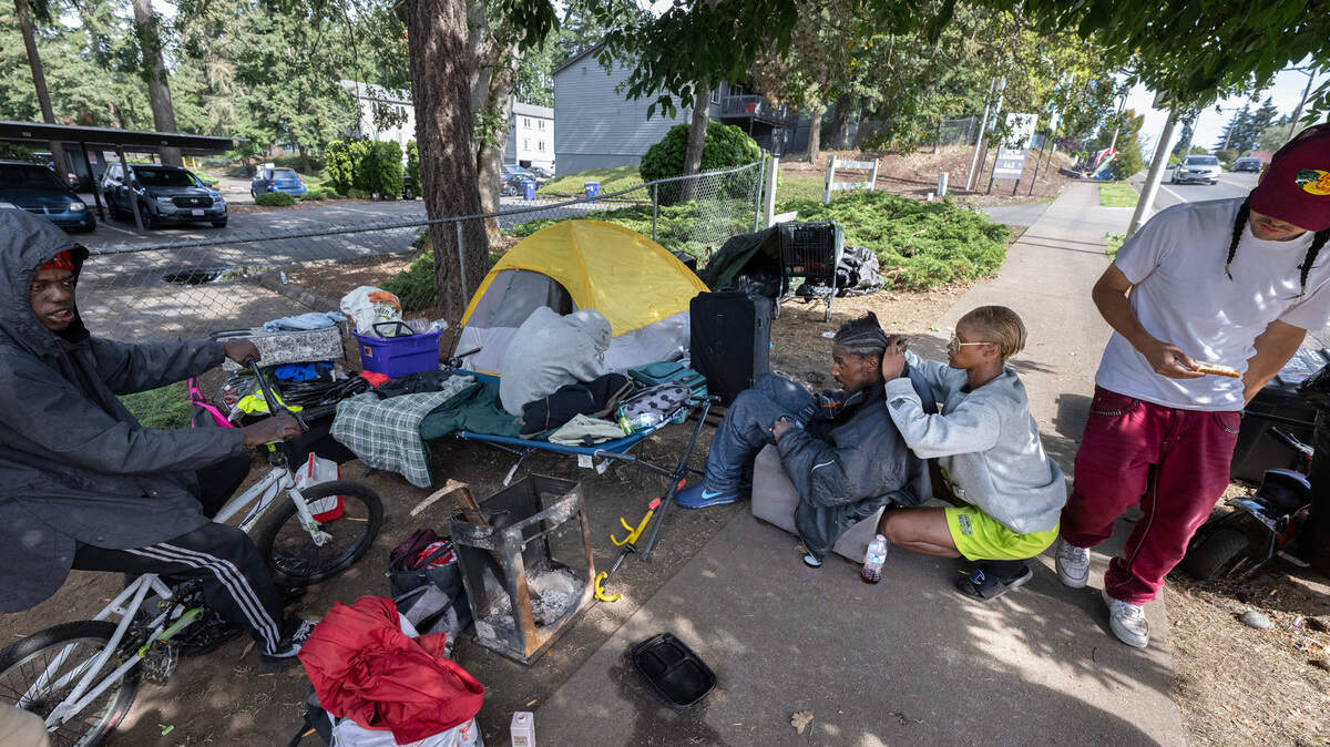 Ariel Williams braids the hair of fellow homeless resident Shamiah at her camp along 96th Street east of Hosmer Street in Tacoma, Washington on Sept. 24, 2024.
