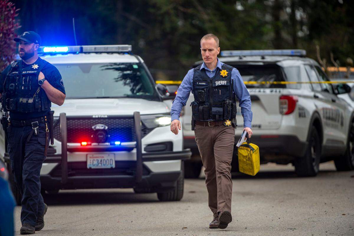 Pierce County Sheriff’s deputies walk away from the scene of a deputy involved shooting near 161st Street East and 62nd Avenue East in Frederickson, on Thursday, May 12, 2022.