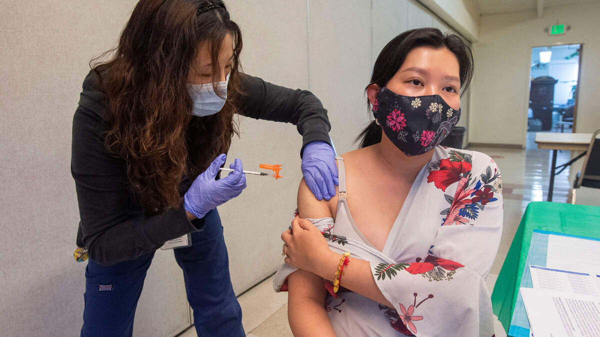 Contract vaccinator Ji Cheong injects native Cambodian Sotha Norton, 35, with her first dose of the Pfizer vaccine at a clinic staged by the Tacoma-Pierce County Health Department at the Asia Pacific Cultural Center in Tacoma Wednesday, June 9, 2021. Norton decided to wait until her baby was delivered before getting immunized because she was “nervous” the vaccine might harm the child.