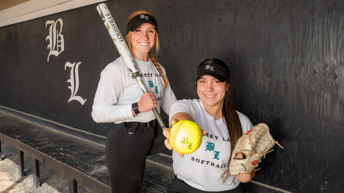 Bonney Lake juniors Kyla Cross, who plays centerfield, and Bella Carazo, who pitches, pose for a portrait in the dugout at their home field in Bonney Lake, Wash., on Thursday, April 14, 2022.