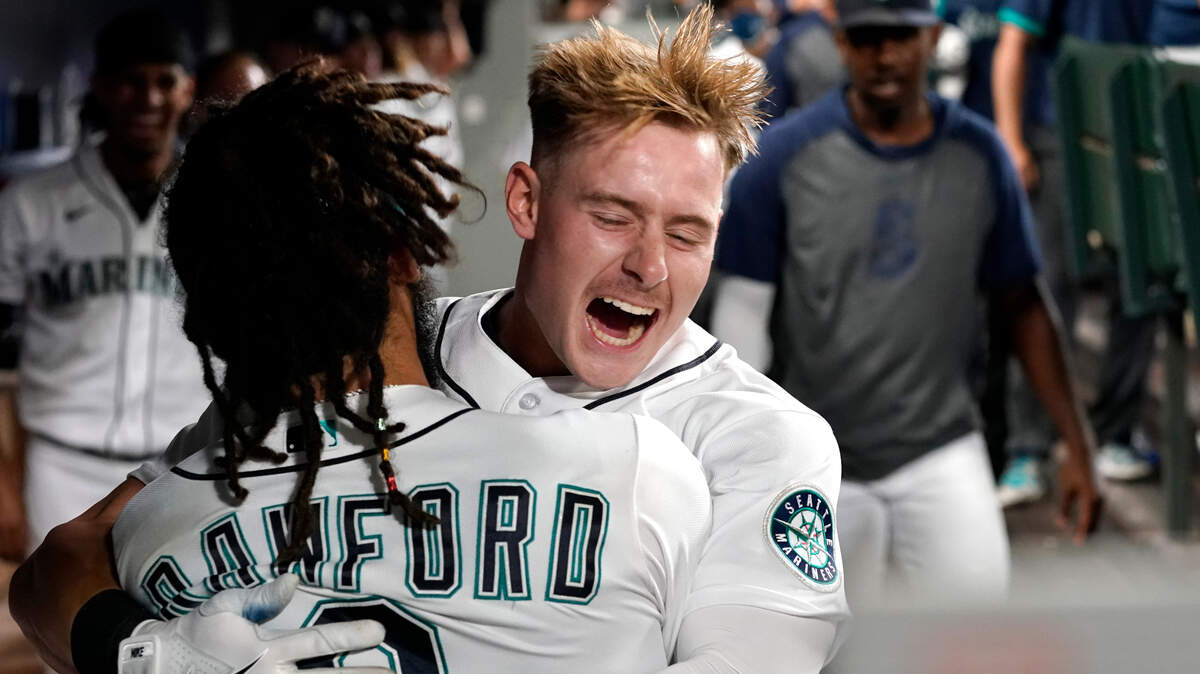 Seattle Mariners’ Jarred Kelenic, right, is embraced by teammate J.P. Crawford following Kelenic’s solo home run against the Toronto Blue Jays in the seventh inning of a baseball game Saturday, Aug. 14, 2021, in Seattle. (AP Photo/Elaine Thompson)