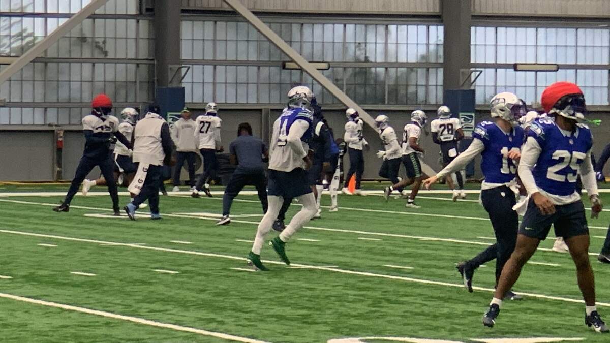 Wide receiver DK Metcalf (14, center) and rookie running back Kenny McIntosh (25, right) returned to practice from injuries Wednesday, Oct. 25, 2023, for the Seahawks’ game against the Cleveland Browns. They are wearing the throwback uniforms the team is wearing for the home game against the Browns Oct. 29, 2023.