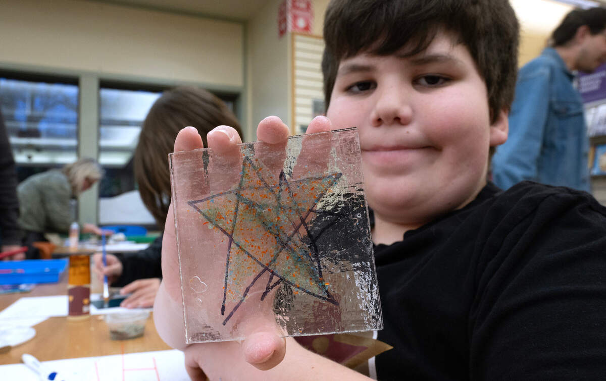 Luke Mattran shows one of his mosiac tiles during the Fused Together workshop at the Kobetich Branch of the Tacoma Public Library in northeast Tacoma on Tuesday, March 5, 2024.