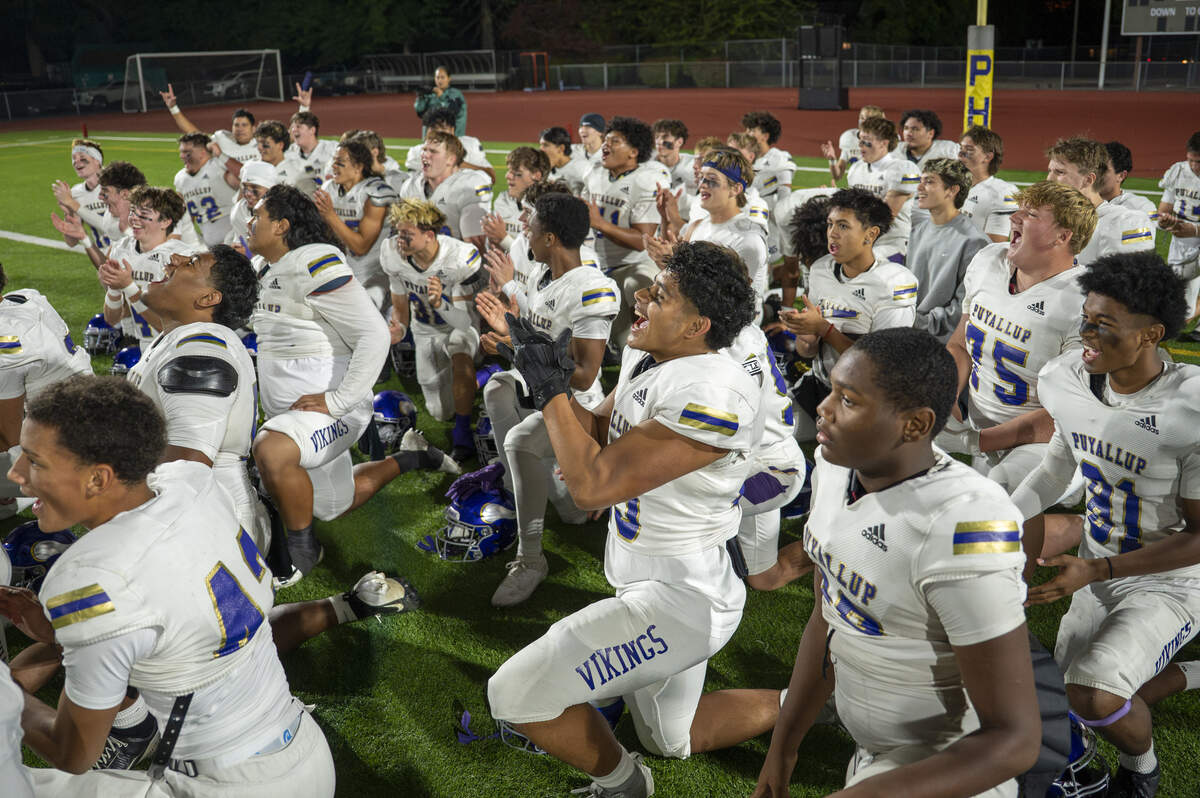 Puyallup players celebrate their win over Emerald Ridge in a post-game huddle on Friday, Sept. 26, 2025, in Puyallup.