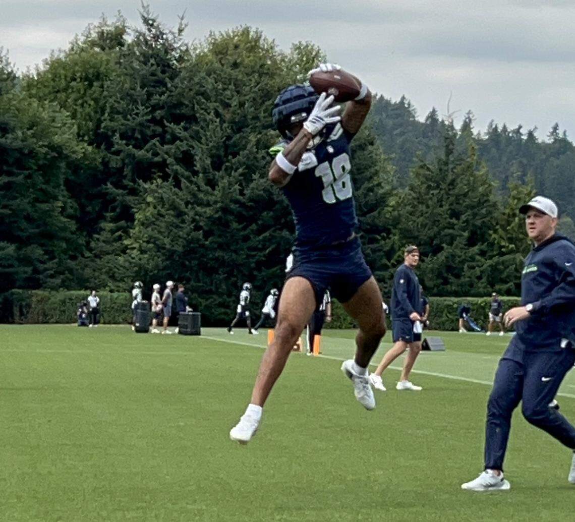 Rookie second-round NFL draft choice Elijah Arroyo leaps to catch a pass from quarterback Sam Darnold in the end zone on the fourth day of Seattle Seahawks training camp, Saturday, July 26, 2025, at the Virginia Mason Athletic Center in Renton.