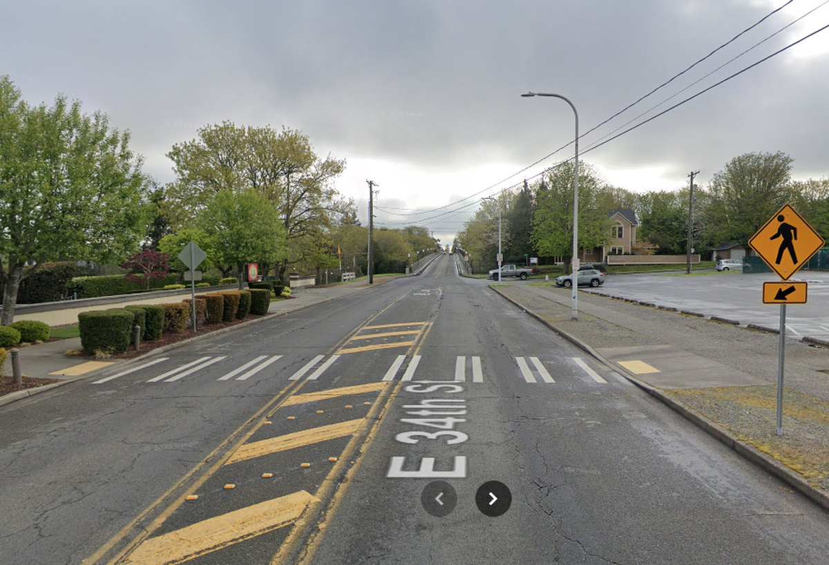 Google Street View depicts East 34th Street in Tacoma in April 2024, with a crosswalk, pedestrian signs and a raised median between two ADA-accessible curb ramps.