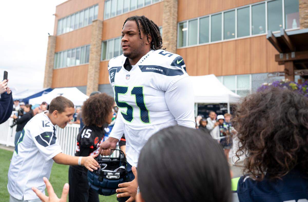 Seattle Seahawks linebacker Jared Ivey (51) high-fives fans during training camp at Virginia Mason Athletic Center on Friday, July 25, 2025, in Renton.
