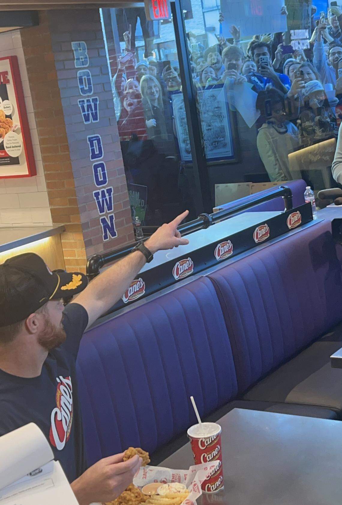 Super Bowl-winning Seahawks quarterback Sam Darnold points to acknowledge fans cheering him through a window of the new Raising Cane's in Seattle’s University District Darnold had a “soft opening” for Tuesday, Feb. 10, 2026.