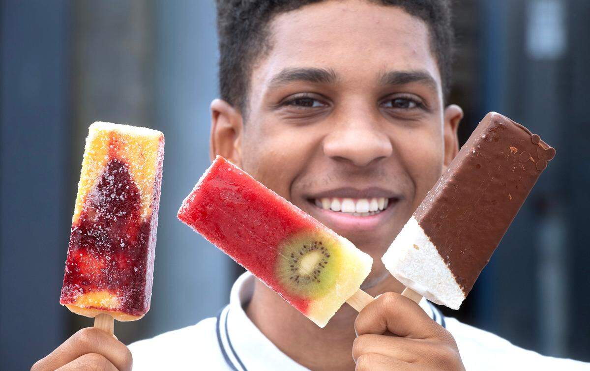 TreJean Jones, the couple’s son and entrepreneur-in-training with a selection of the flavorful — and colorful — gourmet frozen fruit treats at Chill Paletas shop at the Tacoma Farmers Market in Tacoma, Washington, on Thursday, June 22, 2023. From left: Blackberry Peach, Strawberry Pineapple Kiwi and Coconut Chocolate Dipped.