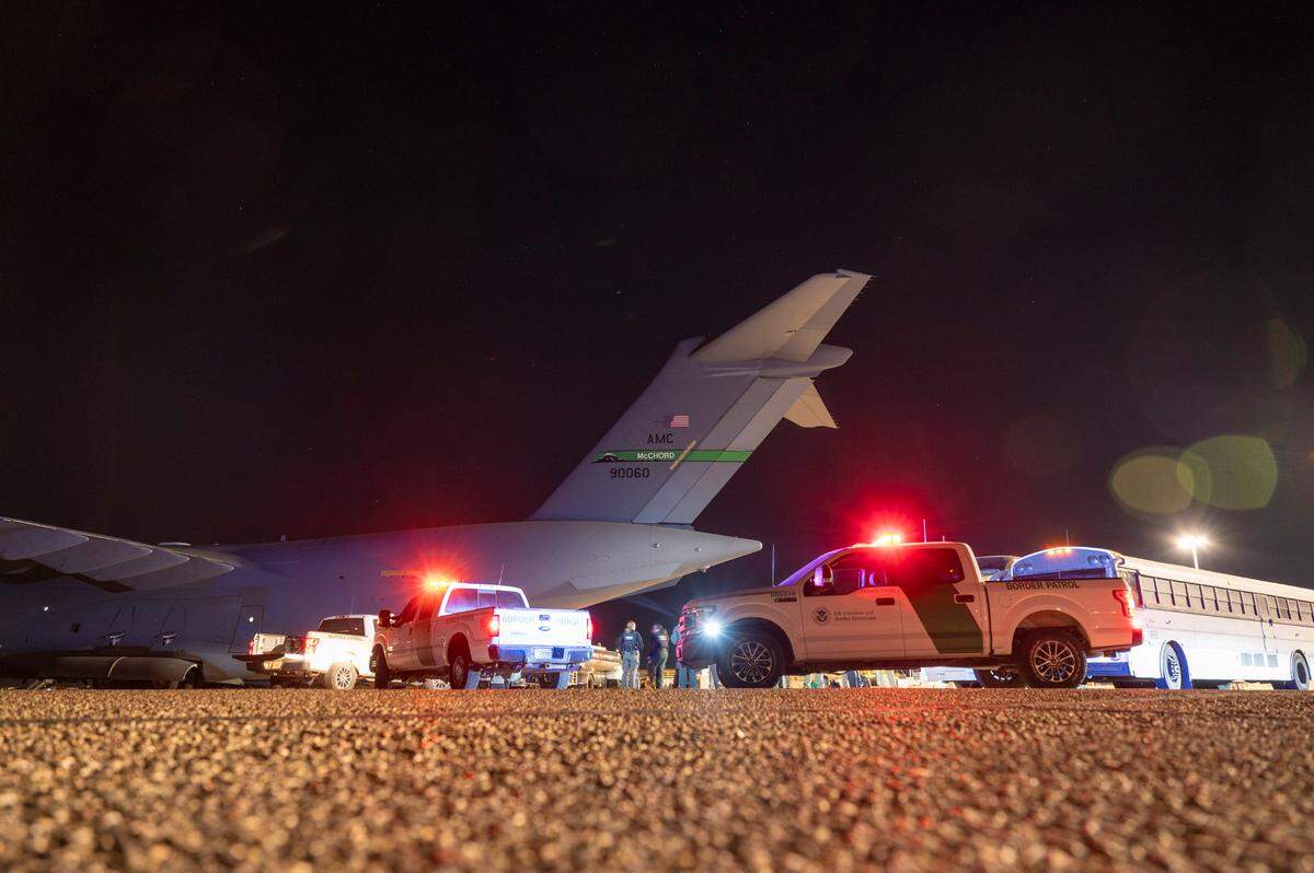 U.S. Airmen and U.S. Customs and Border Protection Agency personnel prepare to load deportees onto a C-17 Globemaster III at Tucson International Airport in Tucson, Ariz., Jan. 23, 2025. Under the direction of U.S. Northern Command, U.S. Transportation Command is supporting Immigration and Customs Enforcement removal flights by providing military airlift. (Dept. of Defense photo by Senior Airman Devlin Bishop)