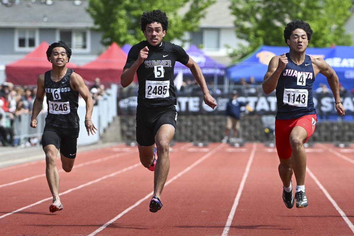 Sumner’s Izear Ferguson, center, pushes ahead in the 4A Boys 100M Dash final on Saturday, May 30, 2026, at the 2026 State Track & Field Championships in Tacoma, Wash. Ferguson finished in first.