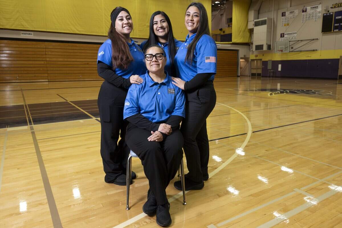 Nadia Tialavea, front, poses with her daughters and fellow referees Jeanieva Tialavea, left, Harmony Tialavea, center, and Lesandra Tialavea for a portrait on Wednesday, Oct. 22, 2025, ahead of a next day matchup that will be refereed by the group at Puyallup High School in Puyallup, Wash. Family members Federal Way head volleyball coach Brooks Tuilaepa and Puyallup head volleyball coach Alexandria Tuilaepa will be coaching the match.