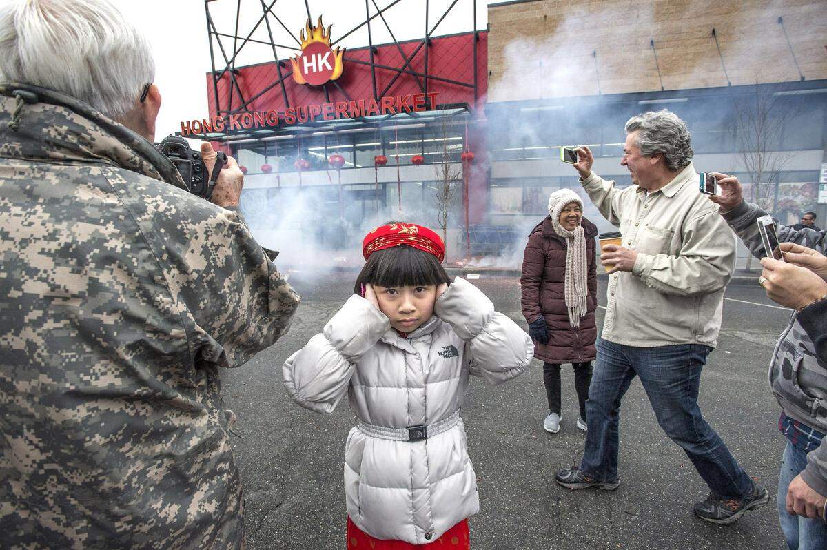 Vicky Nguyen, 9 of Puyallup, protects her hearing from the percussion and cracks of fireworks during a Lunar New Year celebration in the Lincoln Business District of Tacoma in 2016.