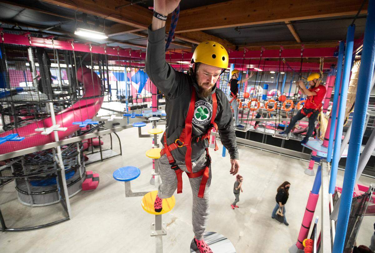 Ryan Campbell of Puyallup navigates the Flying Leopard ropes course ten feet above the ground at Catapult Adventure Park in Puyallup, Washington, on Friday, Dec. 24, 2021.