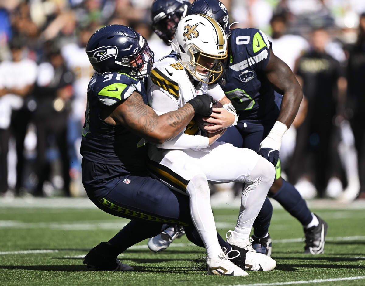 Seattle Seahawks defensive tackle Byron Murphy II (91) wraps up New Orleans Saints quarterback Spencer Rattler (2) during the third quarter of the game at Lumen Field, on Sunday, Sept. 21, 2025 in Seattle.