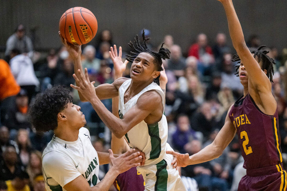 Auburn guard Jaylen Petty (3) drives to the basket for an off-balance shot as O’Dea guard Mason Williams (2) defends during the first quarter of a Class 3A state regionals game on Saturday, Feb. 25, 2023, at Auburn High School in Auburn, Wash.