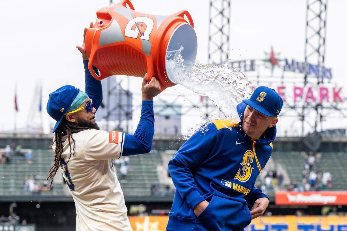 Apr 27, 2025; Seattle, Washington, USA;  Seattle Mariners shortstop J.P. Crawford (3), left, douses starting pitcher Logan Evans (73) after a game against the Miami Marlins at T-Mobile Park. Mandatory Credit: Stephen Brashear-Imagn Images