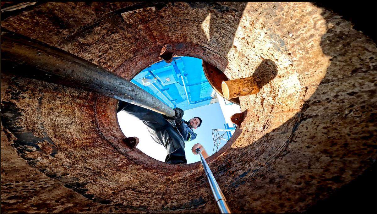 Juan Parada, the lead technician at West Coast Renewables, a Sumner-based cleaning company, empties the large, concrete, gravity grease interceptors under the street behind Edison Square in Tacoma in July. They are accessible only through a sewer manhole.