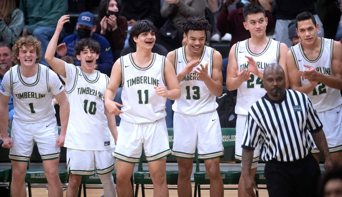 The Timberline Blazer bench (from left) Jackson Brown, Eli Monteagudo-Rodriguez, Ahren Bee-Richards, Kenyon Simmons, Ethan Cornwell and Gage Pedro celebrate a breakaway dunk during Saturday night’s West Central III/Southwest bidistrict tournament boys basketball opening-round game at Timberline High School in Lacey, Washington, on Feb. 12, 2022. Timberline won the game, 70-40.