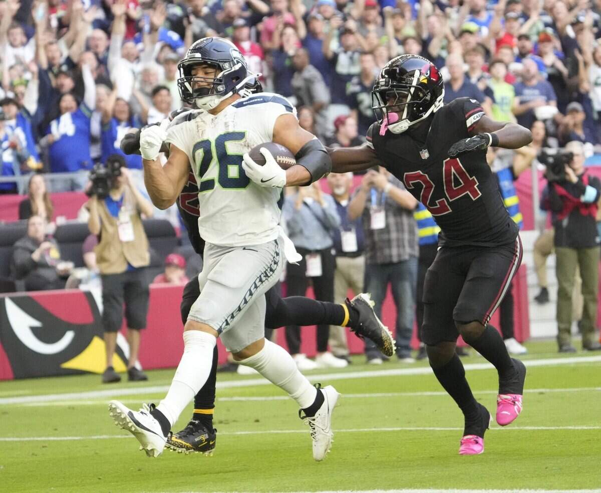 Seattle Seahawks running back Zach Charbonnet (26) runs for a touchdown against Arizona Cardinals cornerback Starling Thomas V (24) during the second quarter at State Farm Stadium in Glendale on Dec. 8, 2024.