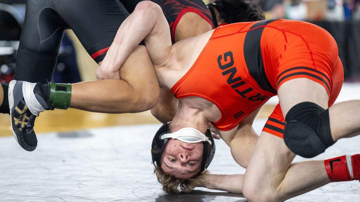 Orting’s Trevor Anderson grabs hold of the legs of Cleveland’s Reese Tanabe during their Class 2A, 120-pound match on Friday, Feb. 21, 2025, at Mat Classic XXXVI at the Tacoma Dome in Tacoma, Wash.