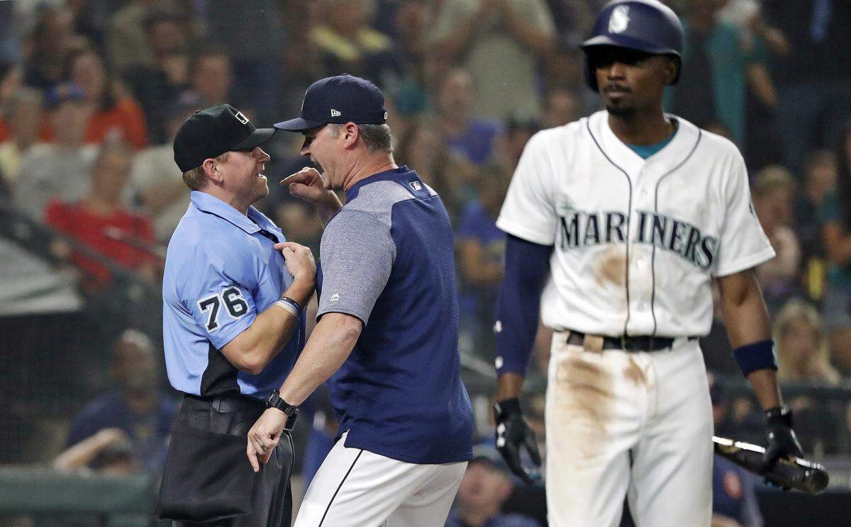 Seattle Mariners manager Scott Servais, center, argues with umpire Mike Muchlinski after being ejected after Servais intervened while Dee Gordon, right, had argued over a strike call in the eighth inning of a baseball game against the Houston Astros, Monday, Aug. 20, 2018, in Seattle. (AP Photo/Elaine Thompson)