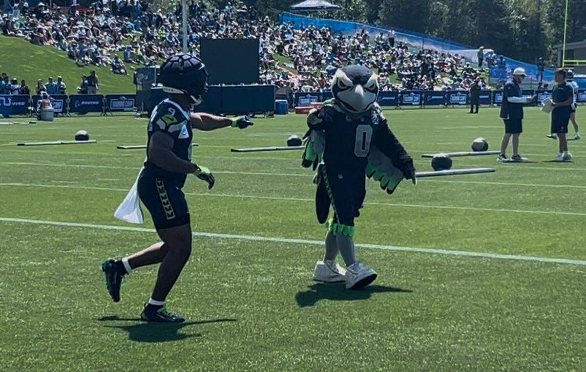 Lead running back Kenneth Walker greeted by Blitz the Seahawks’ mascot at the start of the first practice of Seattle’s NFL training camp Wednesday, July 23, 2025, at the Virginia Mason Athletic Center.
