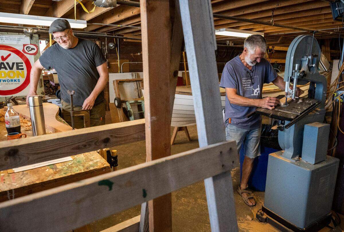 Jonathan Cunningham, right, and Anthony “Mike” Vlahovich, left, cut boards for a Croatian fishing boat that is being built as part of “The Batana Project” at the Gig Harbor Boat Shop in Gig Harbor, Wash. on Wednesday, July 20, 2022. Once the boat is complete, the boat shop will host an event to reveal it Sept. 3.