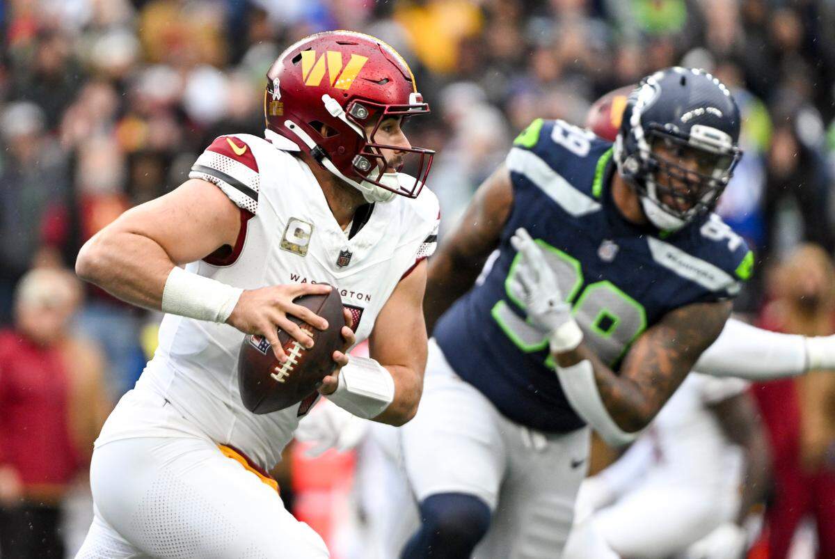 Washington Commanders quarterback Sam Howell (14) scrambles during the first quarter of the game against the Seattle Seahawks at Lumen Field, on Sunday, Nov. 12, 2023, in Seattle, Wash.