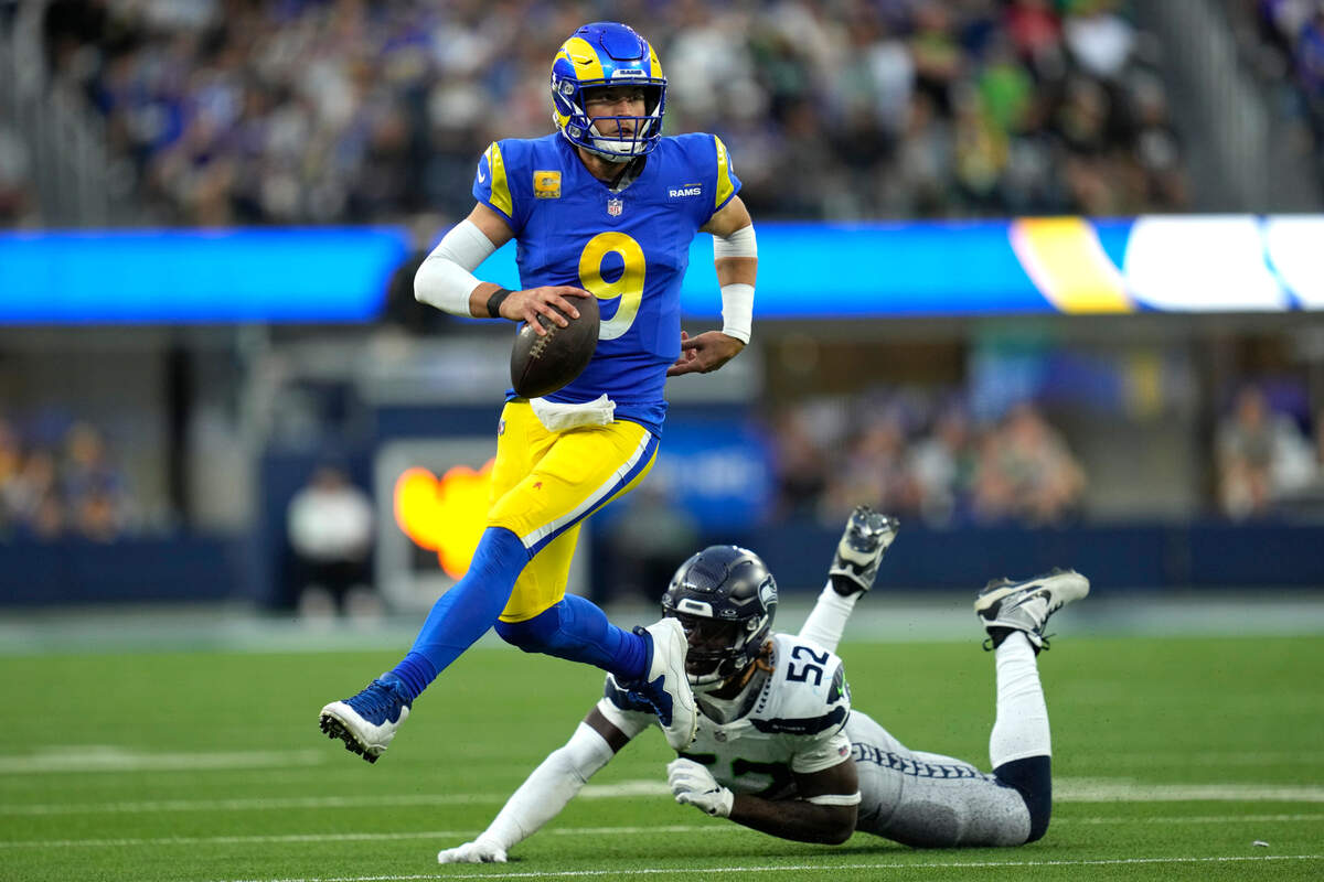 Los Angeles Rams quarterback Matthew Stafford (9) runs the ball after evading a tackle from Seattle Seahawks linebacker Darrell Taylor (52) during the second half of an NFL football game Sunday, Nov. 19, 2023, in Inglewood, Calif. (AP Photo/Ashley Landis)