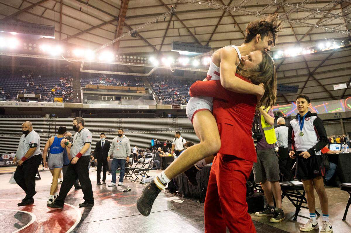 Owen Cline jumps into the arms of Orting head coach Jody Coleman after beating Pullman’s Ivan Acosta, 6-2, in the 138-pound 2A championship match at Mat Classic XXXIII on Saturday, Feb. 19, 2022, at the Tacoma Dome in Tacoma, Wash.