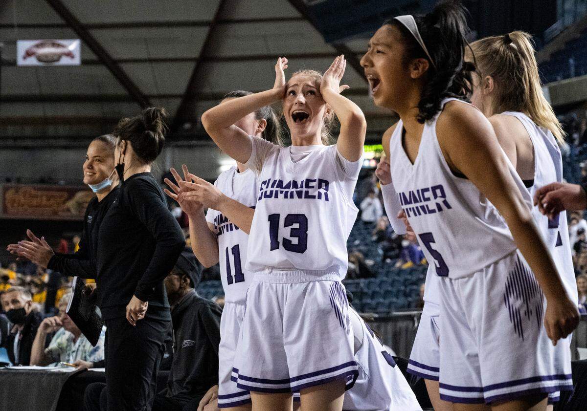 Sumner’s guard Ella Olson (13) and guard Adriana Perez (5) cheer on their teammates from the bench during the Class 4A quarterfinal state tournament game on Thursday, March 3, 2022, at the Tacoma Dome, in Tacoma, Wash.