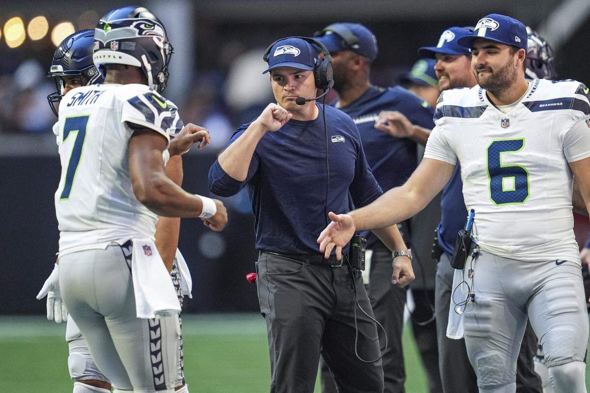 Oct 20, 2024; Atlanta, Georgia, USA; Seattle Seahawks head coach Mike Macdonald reacts with quarterback Geno Smith (7) after a touchdown against the Atlanta Falcons at Mercedes-Benz Stadium. Mandatory Credit: Dale Zanine-Imagn Images