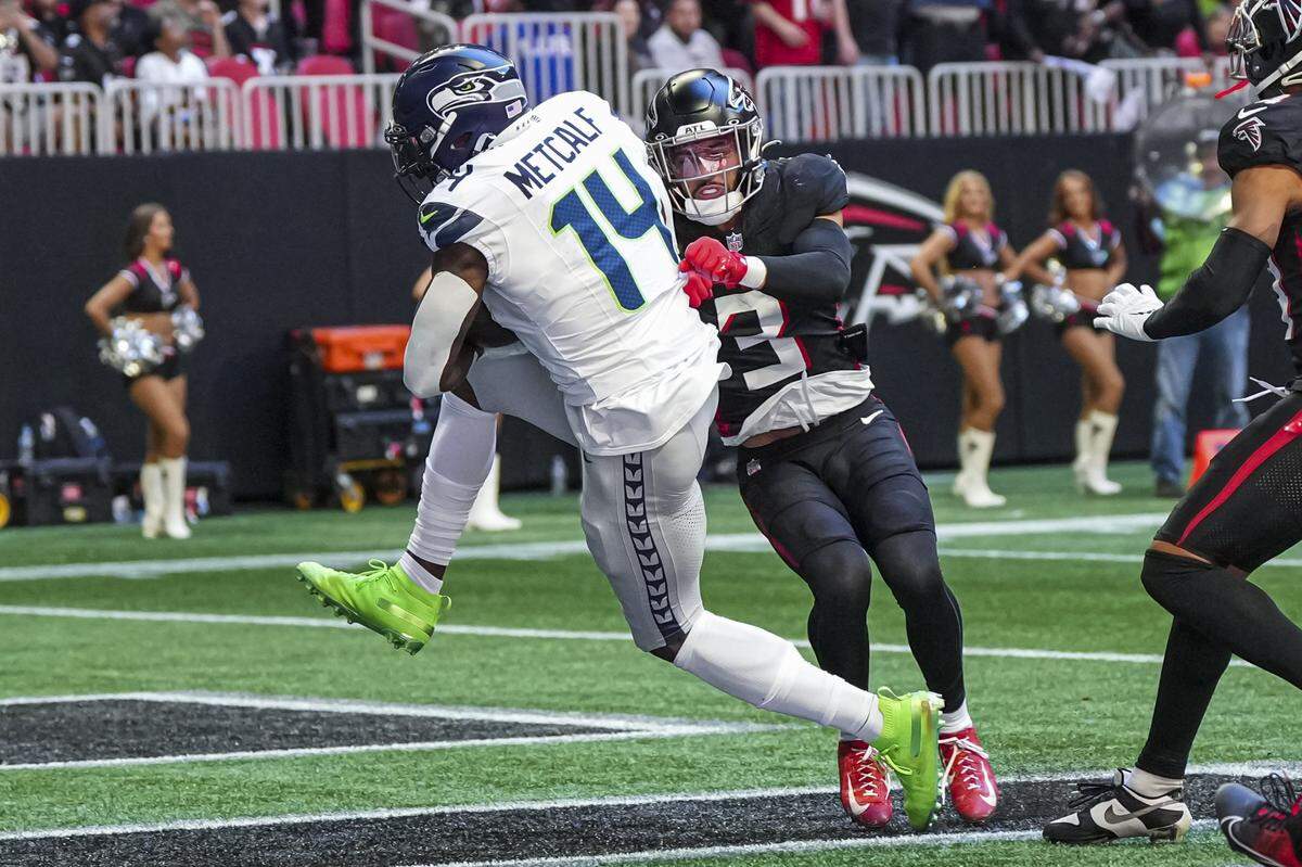 Oct 20, 2024; Atlanta, Georgia, USA; Seattle Seahawks wide receiver DK Metcalf (14) catches a touchdown pass behind Atlanta Falcons safety Jessie Bates III (3) during the first half at Mercedes-Benz Stadium. Mandatory Credit: Dale Zanine-Imagn Images
