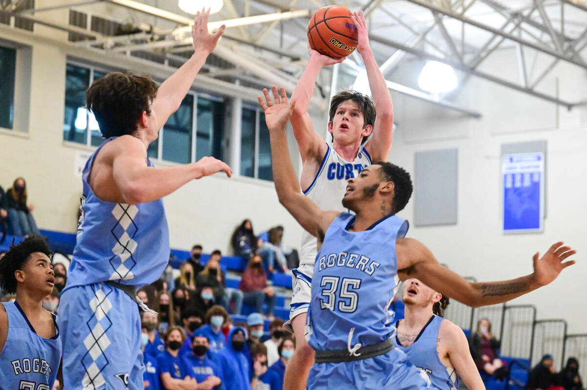 Curtis guard Tyce Paulsen (1) attempts a jump shot while Rogers forward Jaylen Smith (35) defends as time runs out in the first quarter of a 4A South Puget Sound League tournament semifinal game on Friday, Feb. 4, 2022, at Curtis High School in University Place, Wash. Paulsen made the shot.