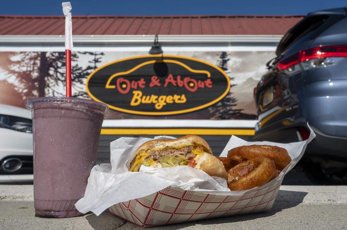 A black raspberry shake, double cheeseburger and onion rings from Out and About Burgers are pictured outside of the drive-thru burger spot on Tuesday, Oct. 7, 2025, in Puyallup, Wash.