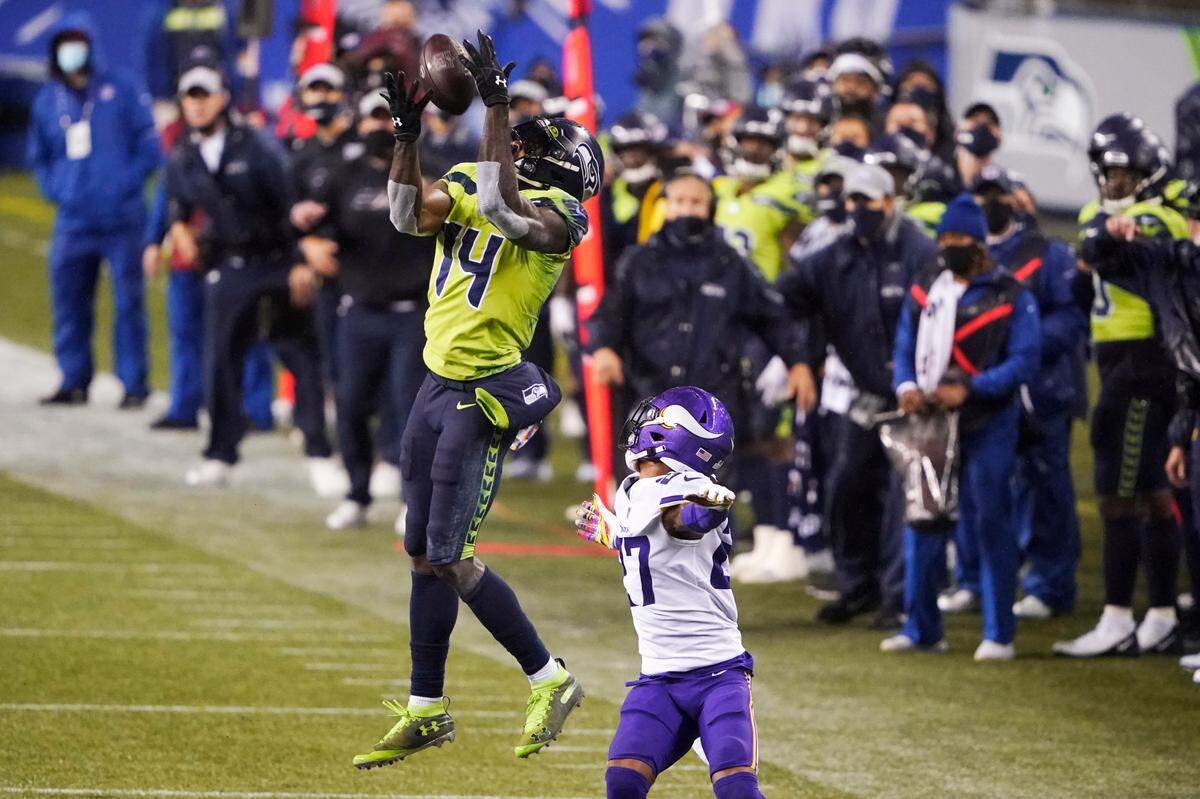 Seattle Seahawks’ DK Metcalf (14) pulls in a long pass reception on the Seahawks’ last series of an NFL football game as Minnesota Vikings’ Cameron Dantzler defends late in the second half, Sunday, Oct. 11, 2020, in Seattle. The Seahawks won 27-26. (AP Photo/Ted S. Warren)