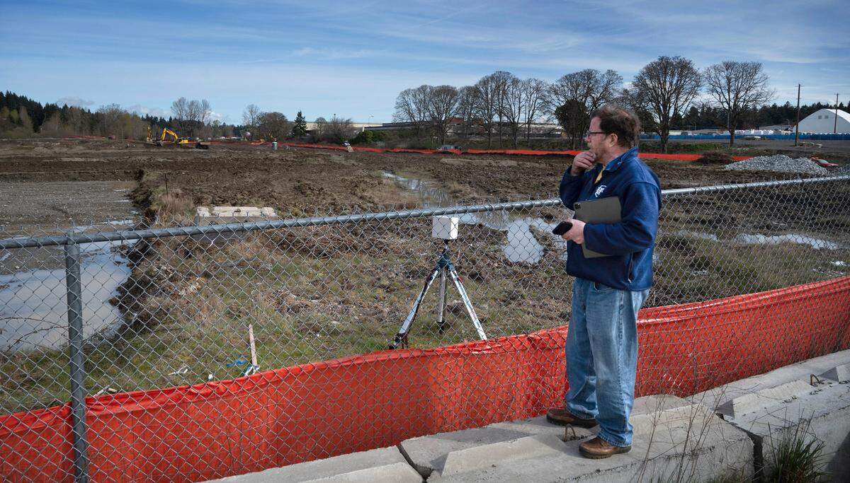 Retired architect Kit Burns of Tacoma watches the ground work under way at the 2.5-million-square-foot Bridge Industrial warehouse site in south Tacoma on Friday, March 29, 2024.