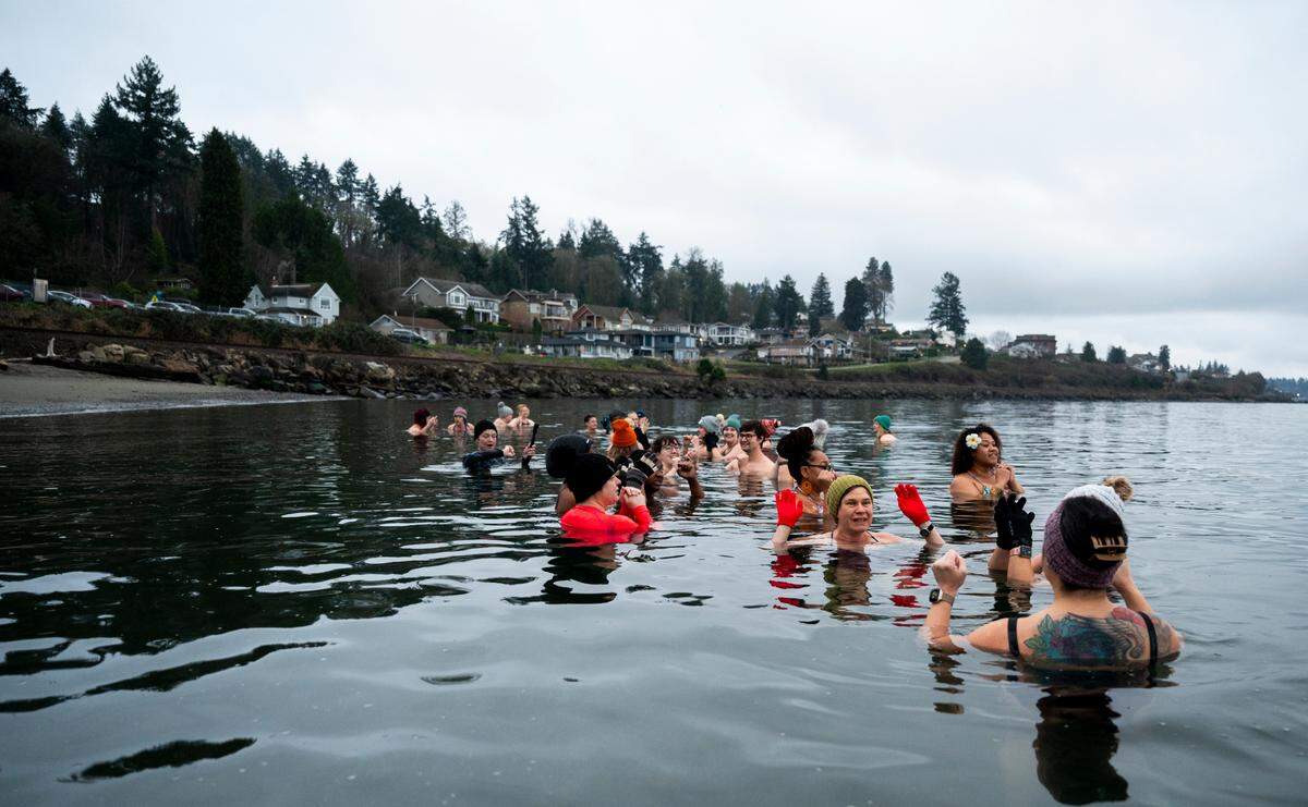 The Puget Sound Plungers group sit in the frigid waters of the Puget Sound at Sunnyside Beach, on Sunday, Jan. 12, 2025, in Steilacoom, Wash.