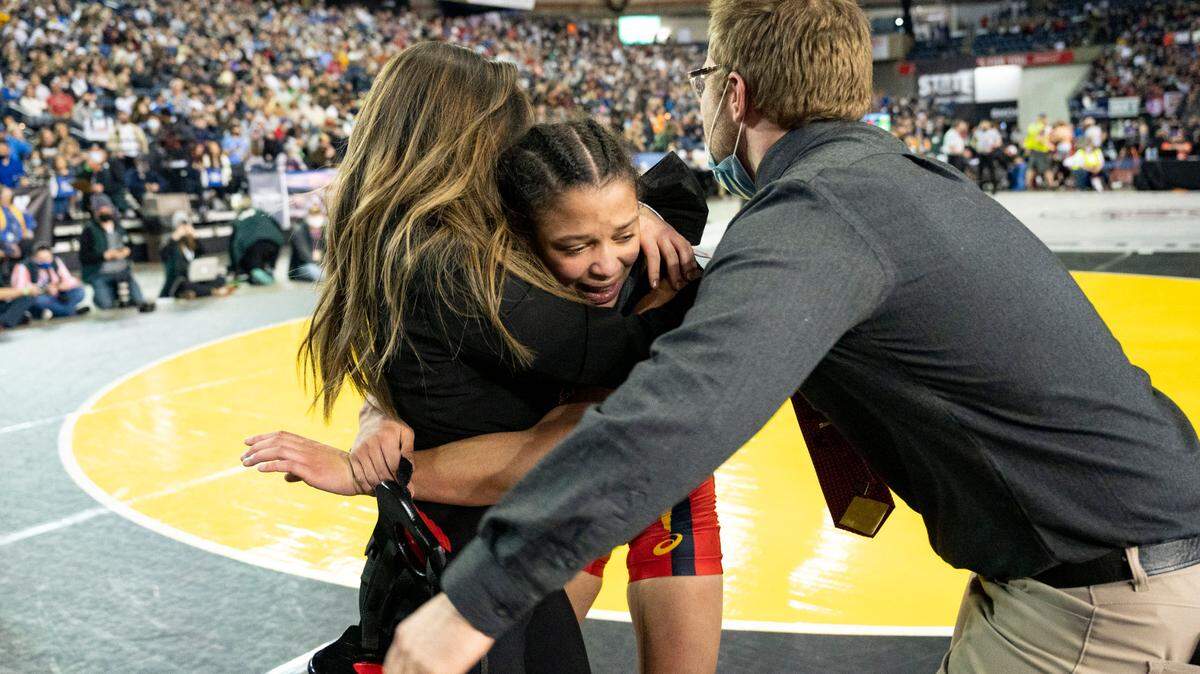 Mount Tahoma’s Zeta Lee celebrates with her coaches after beating Toppenish’s Mia Zuniga 110-pound girls championship match at Mat Classic XXXIII on Saturday, Feb. 19, 2022, at the Tacoma Dome in Tacoma, Wash. Lee won by major decision, 9-0.
