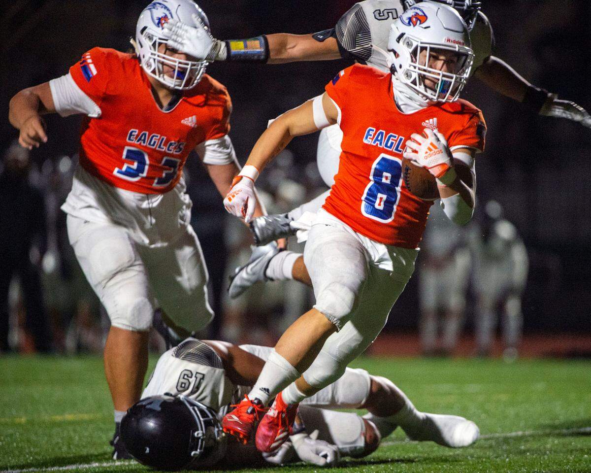 Graham-Kapowsin running back Zack Lee skips over a tackle attempt by Kentwood’s Ezrah Tuaoa on his way to the endzone for a rushing touchdown during the second quarter of a first-round State 4A game on Friday night at Art Crate Field in Spanaway.